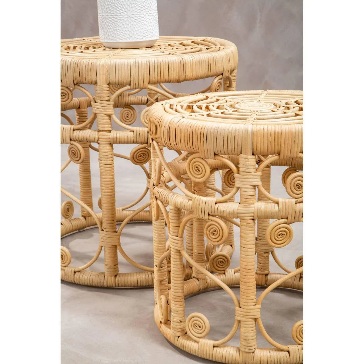 Round rattan side tables with scrollwork design, natural finish, close-up view