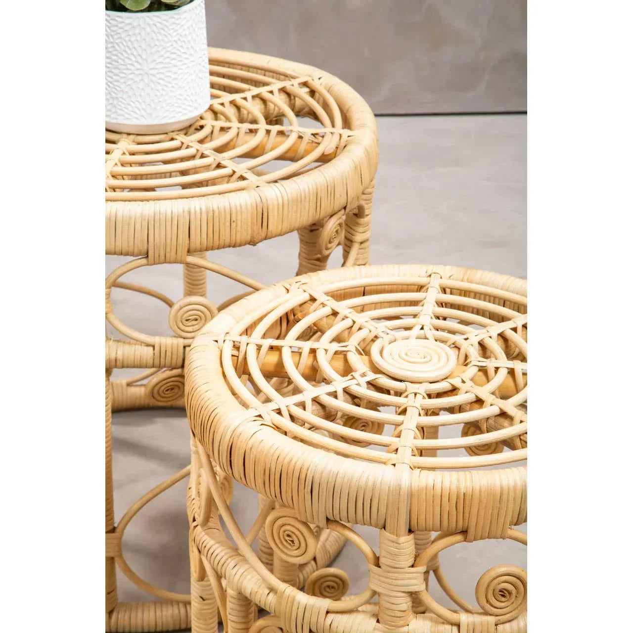 Round rattan side table set with woven tops and spiral detailing, close-up view
