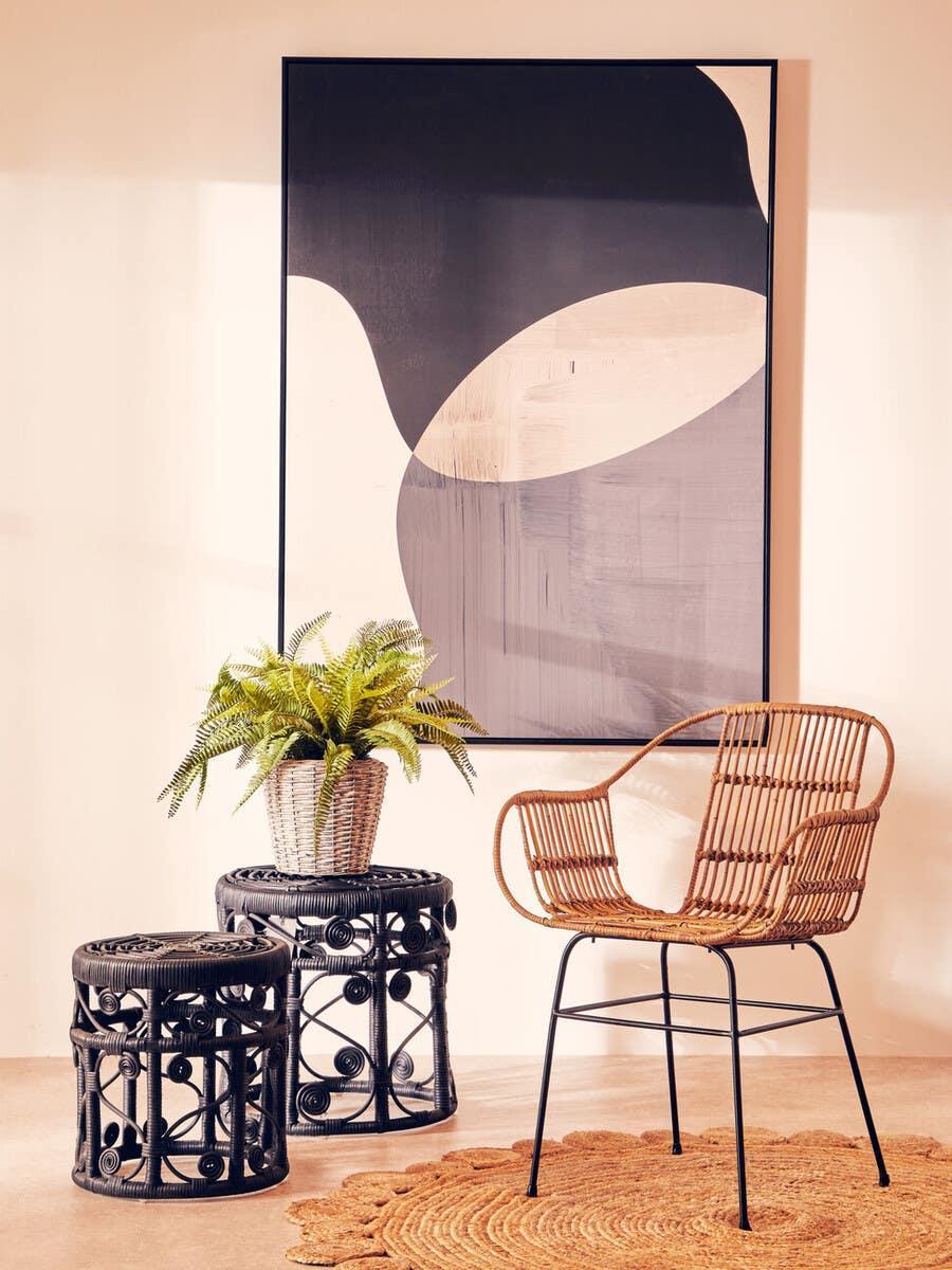 Rattan dining chair with black metal legs and matching tables in modern living room