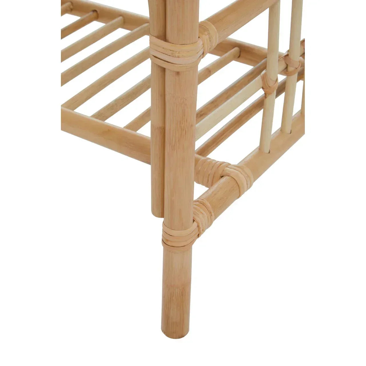 Closeup of rattan furniture leg and lower slatted shelf, natural finish, angled view