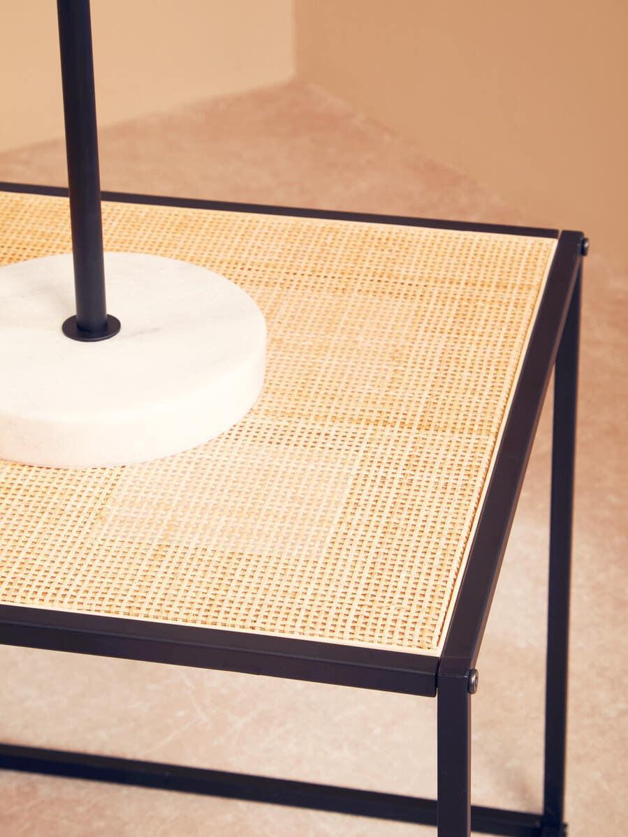 Rectangular rattan side table with black metal frame and marble decor, close-up view