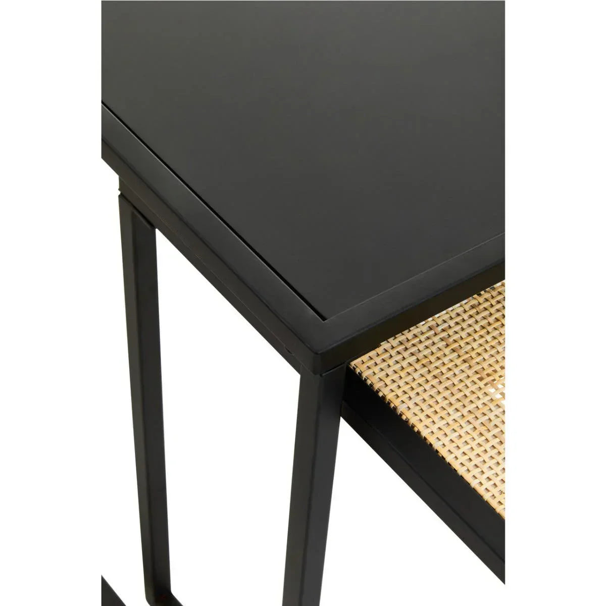 Black metal side table with woven rattan shelf and angular legs, corner detail view