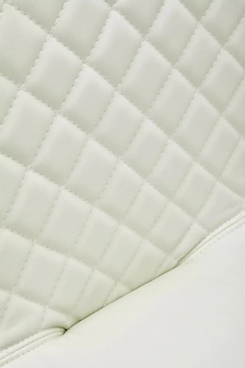 Close-up of cream quilted faux leather upholstery on furniture seat back
