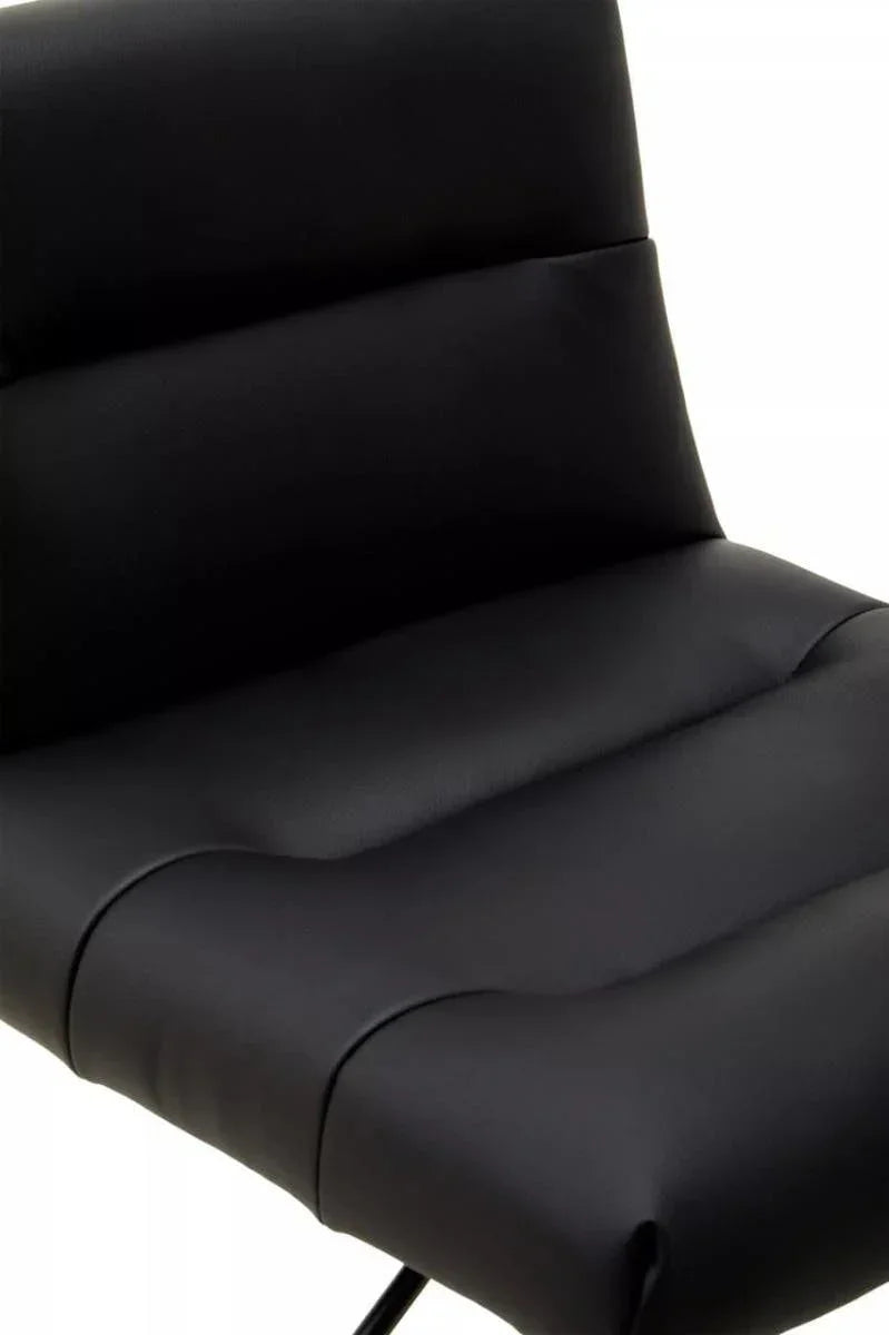 Close-up of black leather dining chair seat with padded detail and stitching