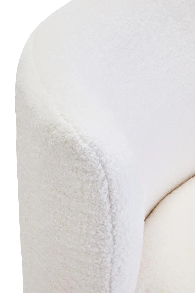 Close-up of white boucle fabric armchair corner with curved arm and soft upholstery