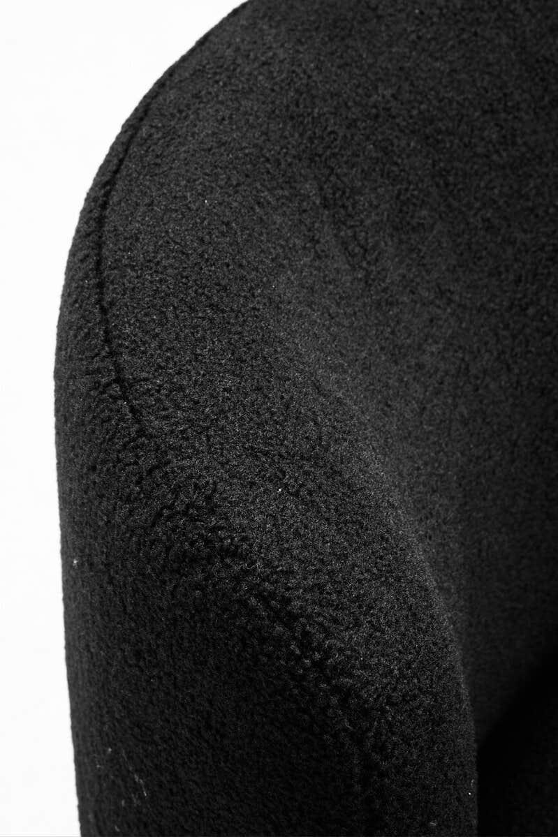 Curved close-up of textured black fabric accent chair armrest
