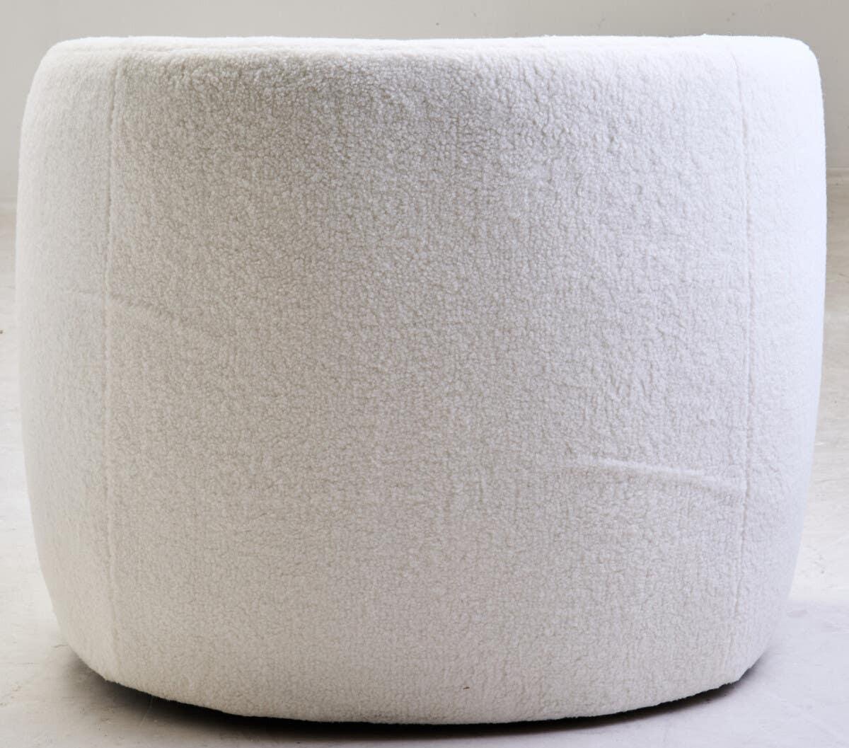 Round boucle ottoman upholstered in white fabric on light floor