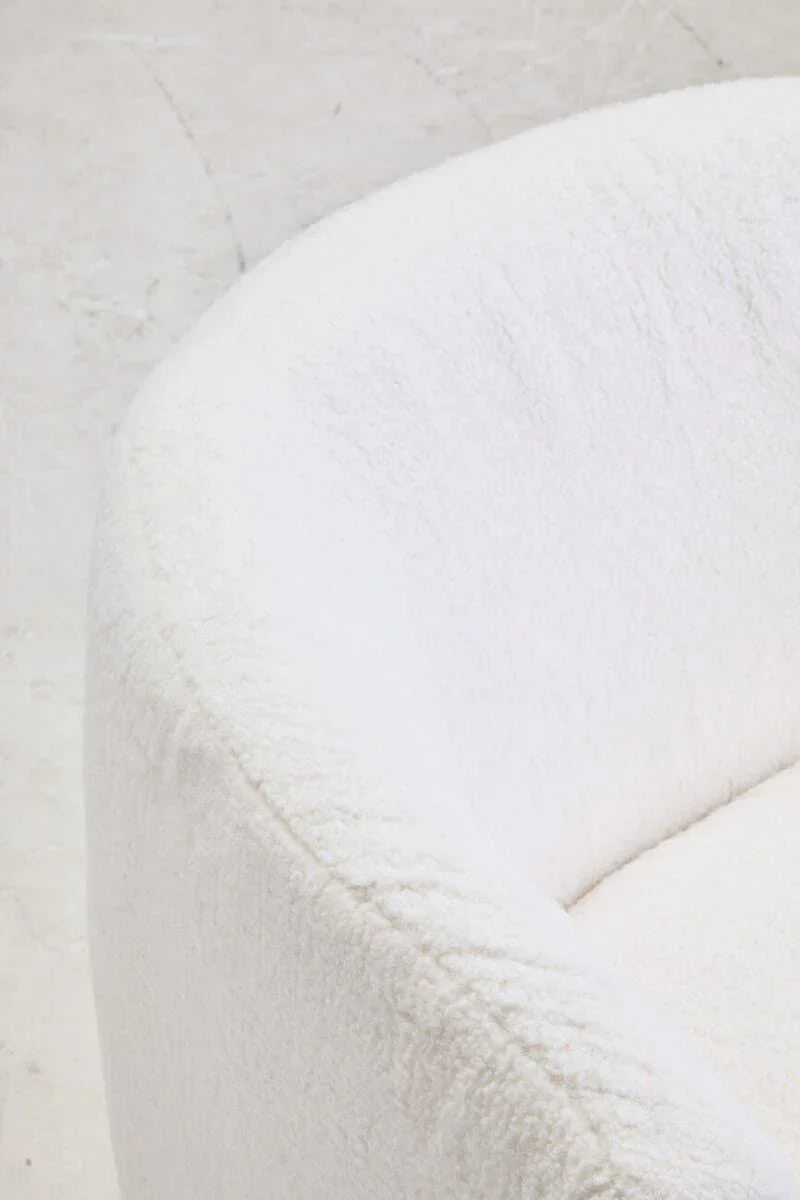 Close-up of white boucle armchair with curved backrest