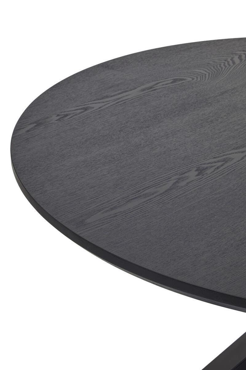 Closeup of round black wood dining table top with visible grain pattern