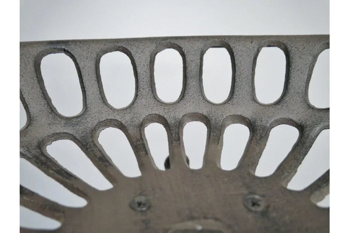 Close-up of metal stool seat with oval cutout pattern and textured finish