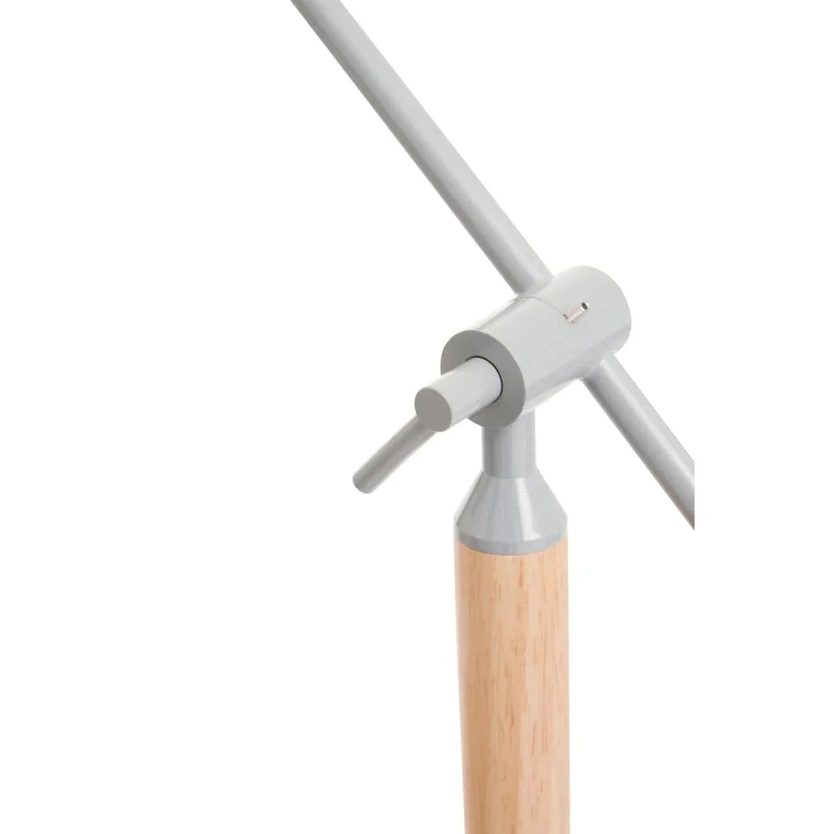 Close-up of adjustable desk lamp with light wood base and matte grey metal arms