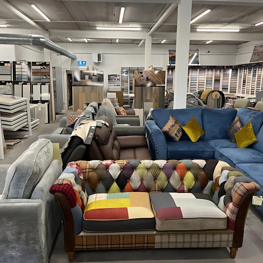 Patchwork fabric sofa with tufted back in furniture showroom, surrounded by modern sofas