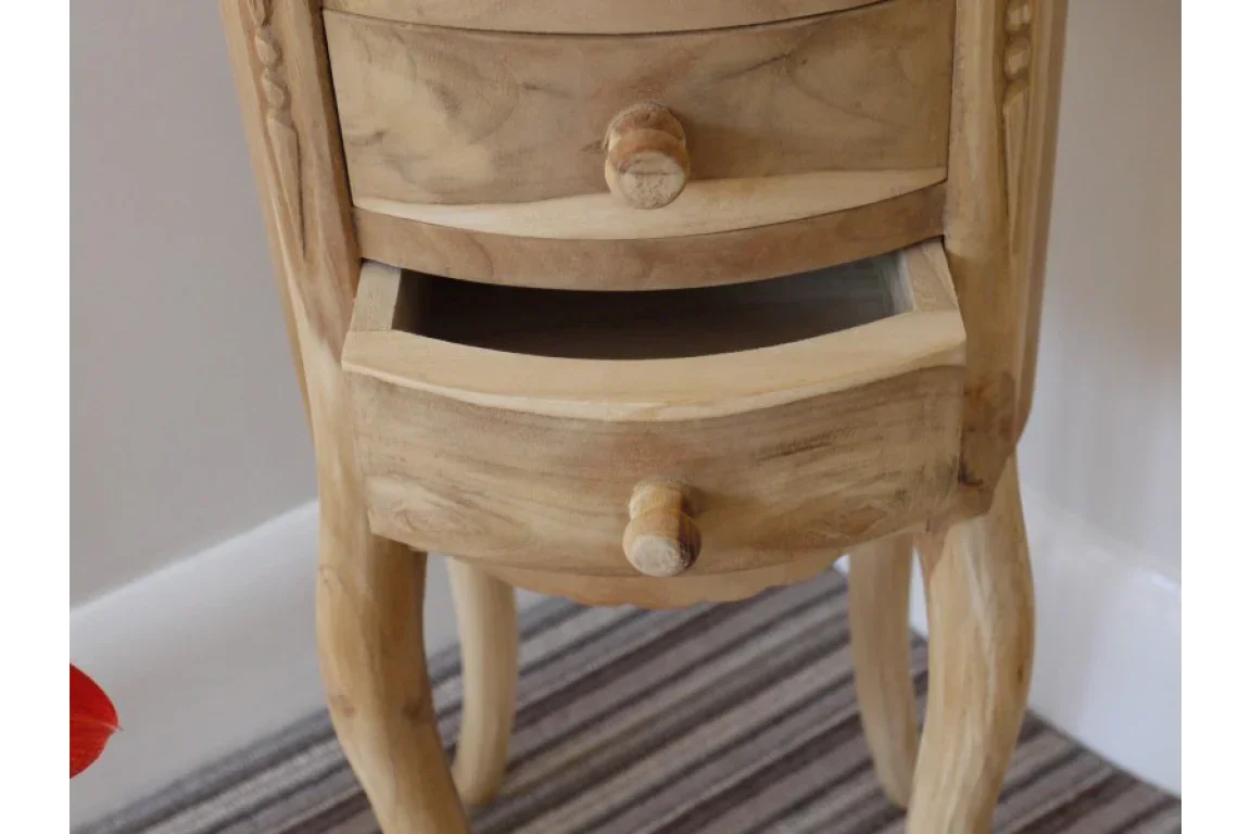 Natural wood bedside table with curved legs and open drawer on striped carpet