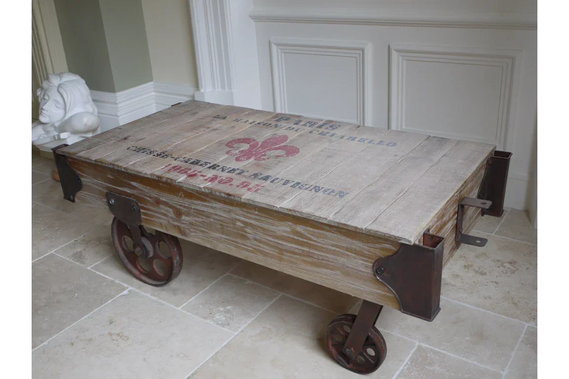 Rustic wooden coffee table with metal wheels and industrial accents on tiled floor
