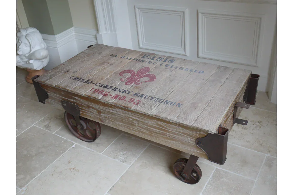 Rustic industrial coffee table with wooden plank top and metal wheels on tiled floor