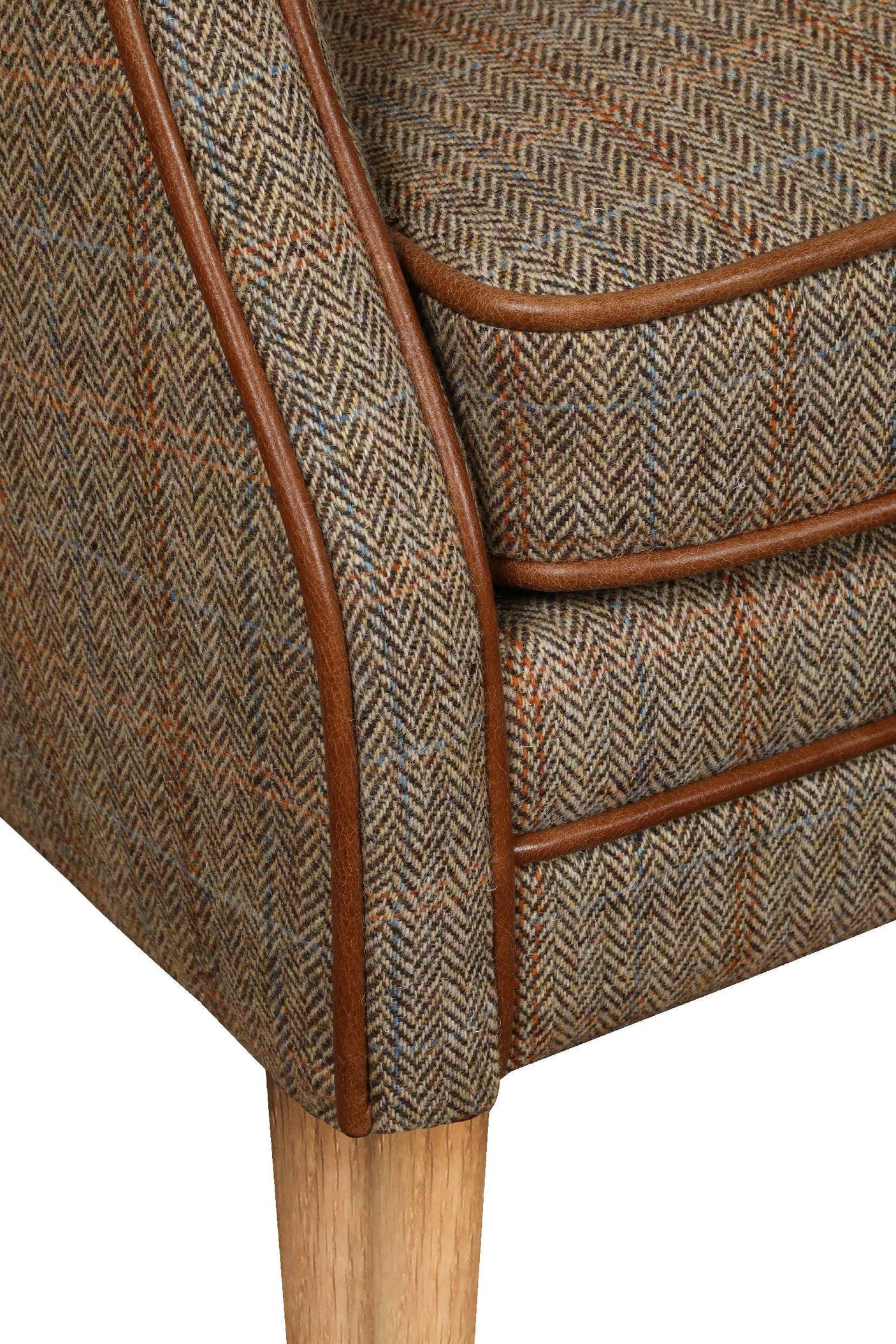 Herringbone fabric armchair with brown leather trim and light wooden leg closeup