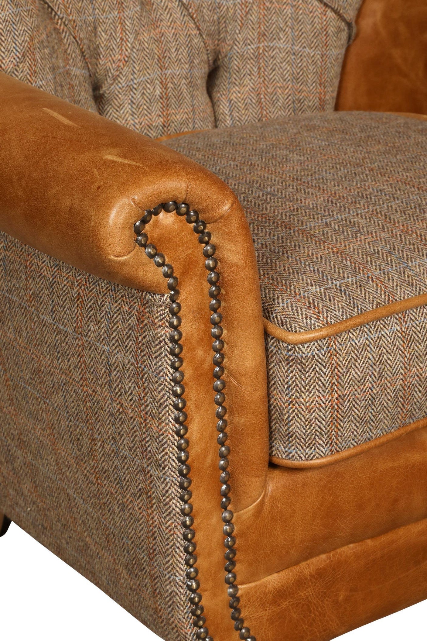 Close-up of brown leather and tweed armchair with studded trim