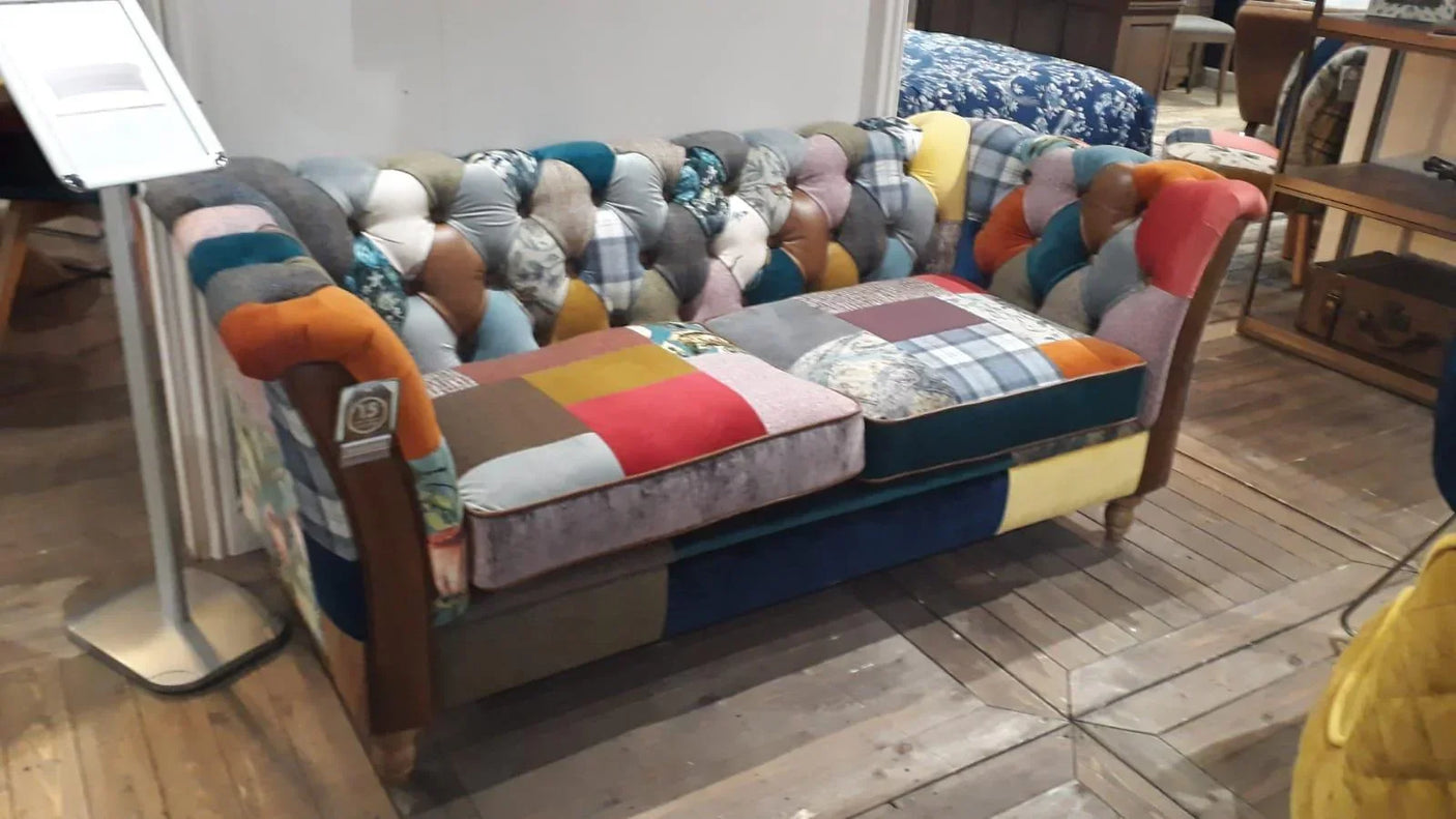 Patchwork fabric sofa with tufted backrest and wooden legs in showroom setting