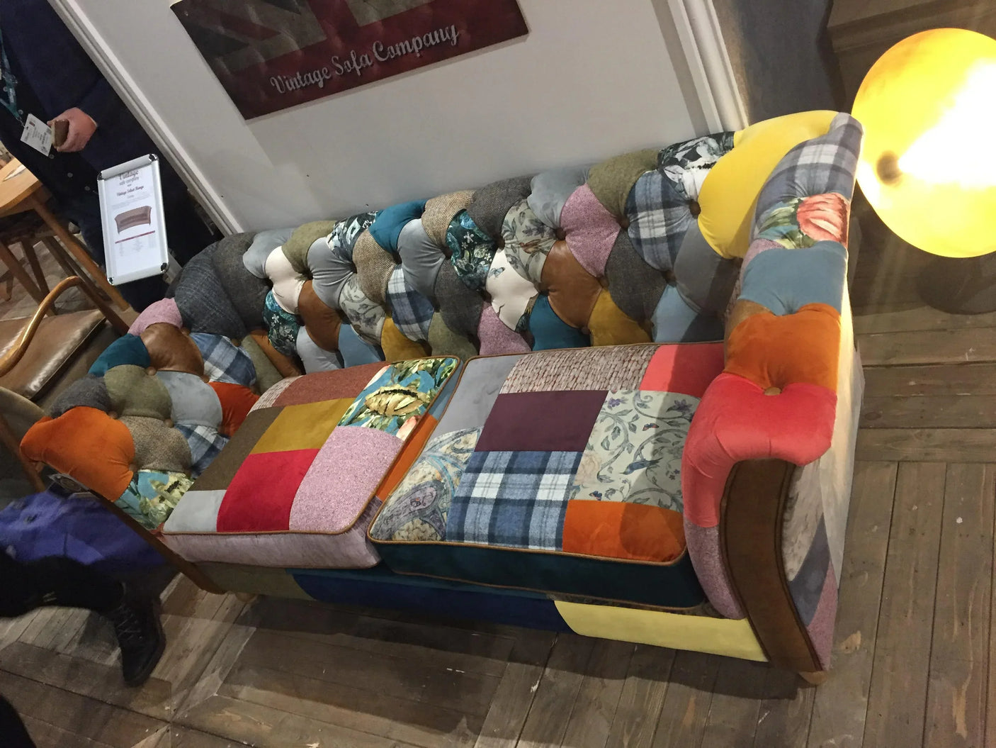 Patchwork fabric sofa with multicoloured tufted upholstery in a living room setting