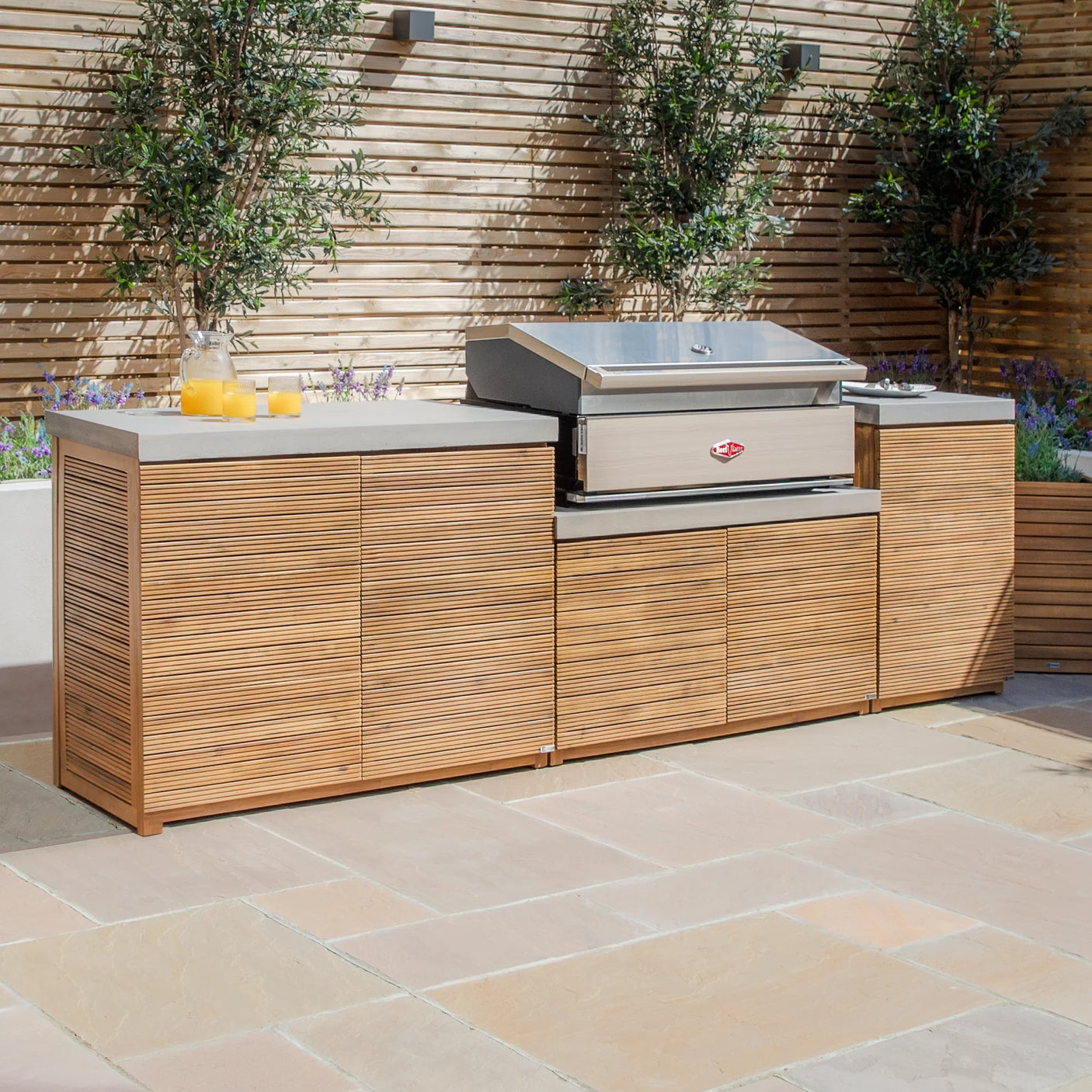 Outdoor kitchen unit with wood panels, stainless steel barbecue grill and concrete worktop