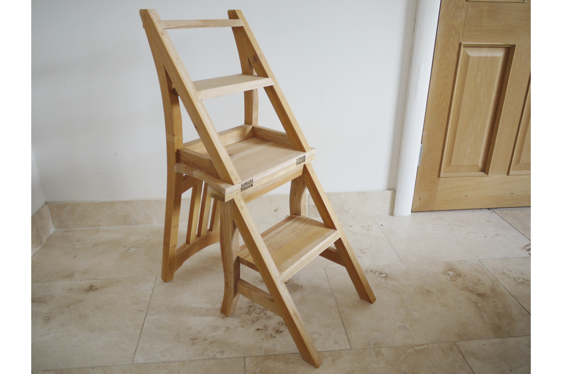 Unfinished light wood chair with foldable steps, shown at an angle on a beige tiled floor near a wooden door.