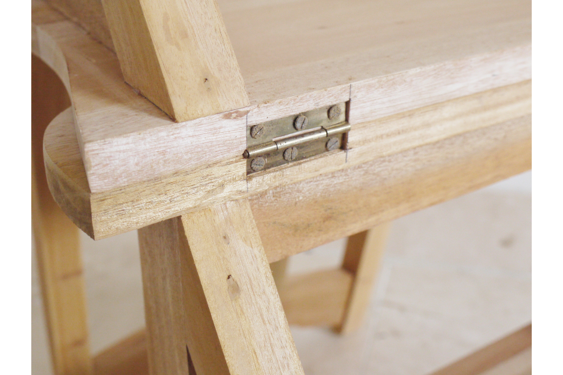 Close-up of unfinished light wood chair step detail showing metal hinge and natural wood grain angle view.