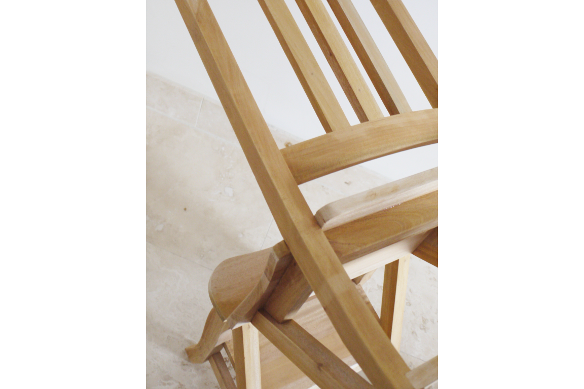 Unfinished wooden chair with slatted back and step stool feature, angled view on light stone floor.