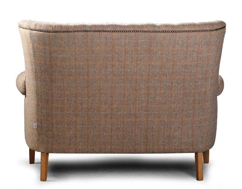 Back view of fabric sofa with wooden legs and studded trim