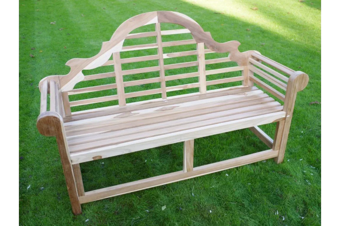 Natural wooden garden bench with slatted seat and decorative arched backrest on grass