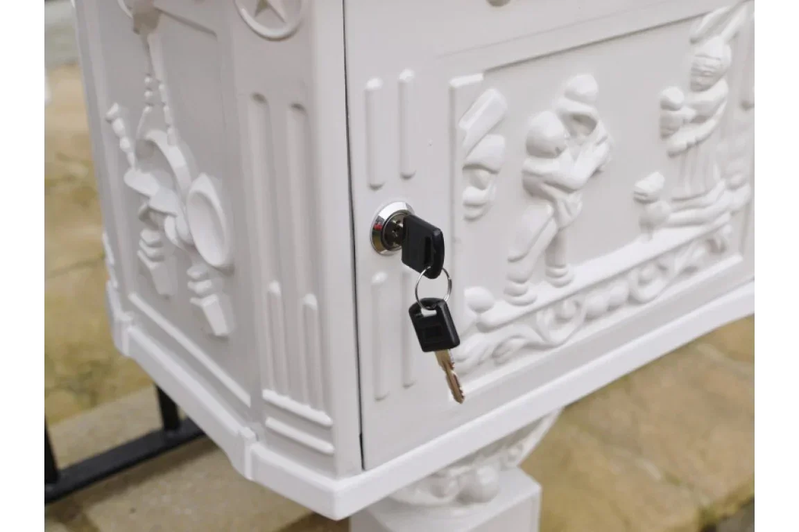 white metal lockable post box with embossed figures and keys in lock