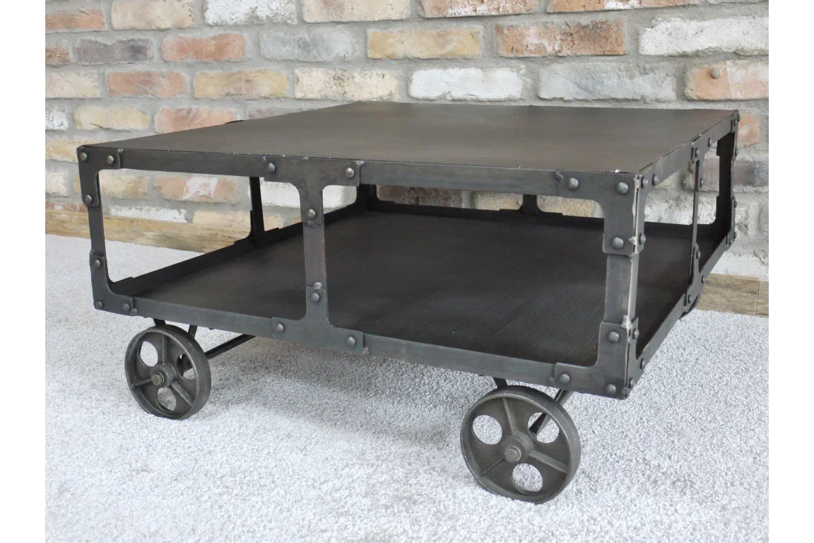 Industrial metal coffee table with wheels and open lower shelf on grey carpet