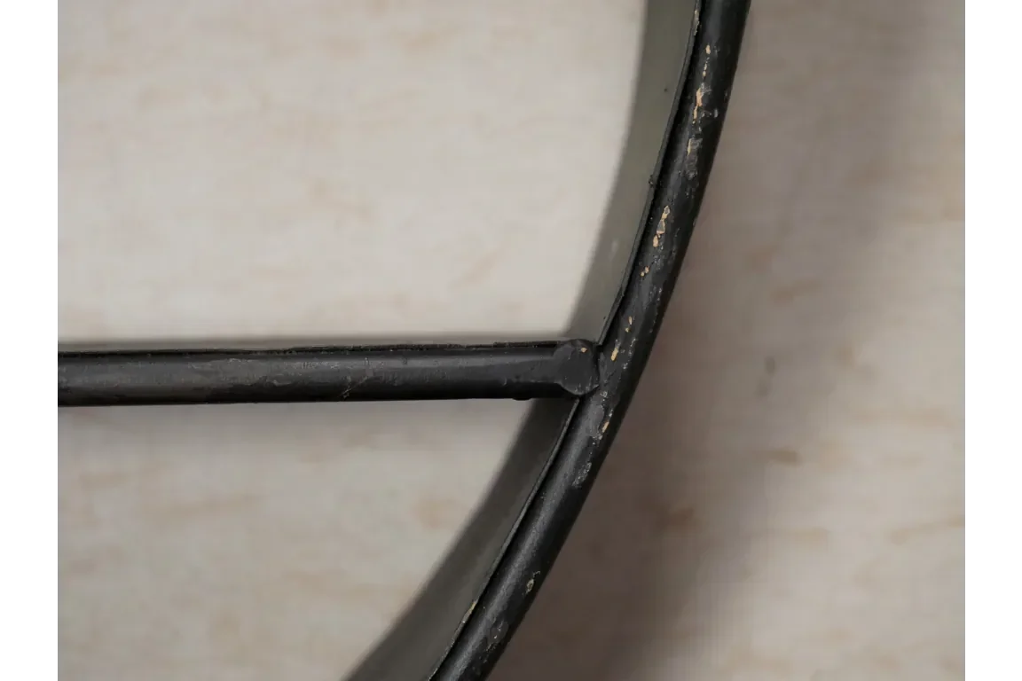 close-up of black metal frame with distressed finish on light background