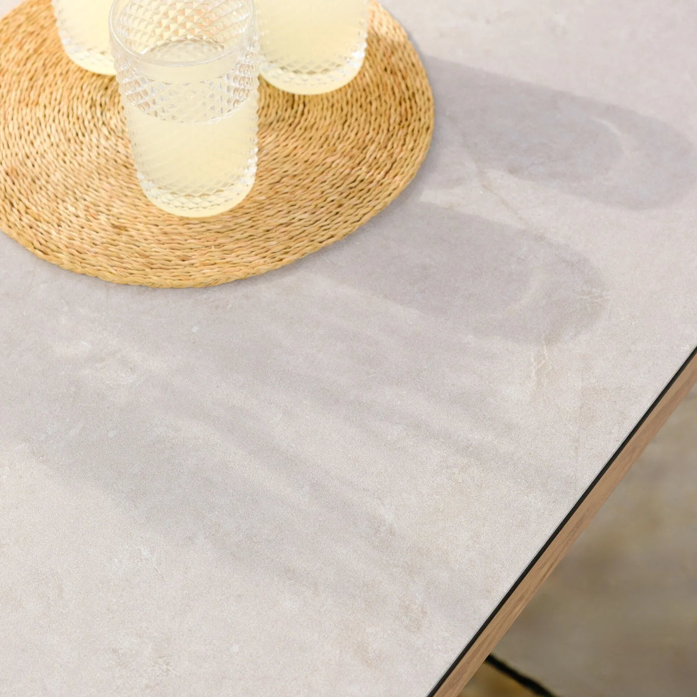 Ceramic outdoor dining table top with woven placemat and textured glass tumblers