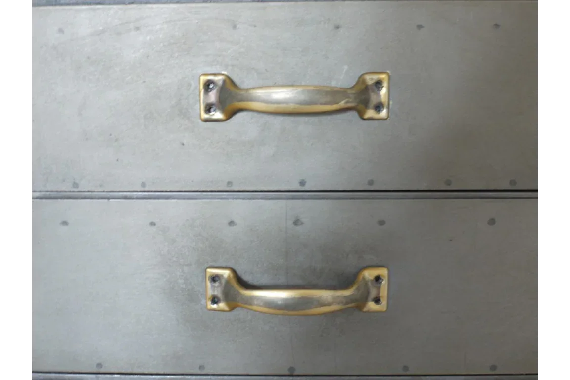 Metal drawer unit with brass handles and rivet detail front view