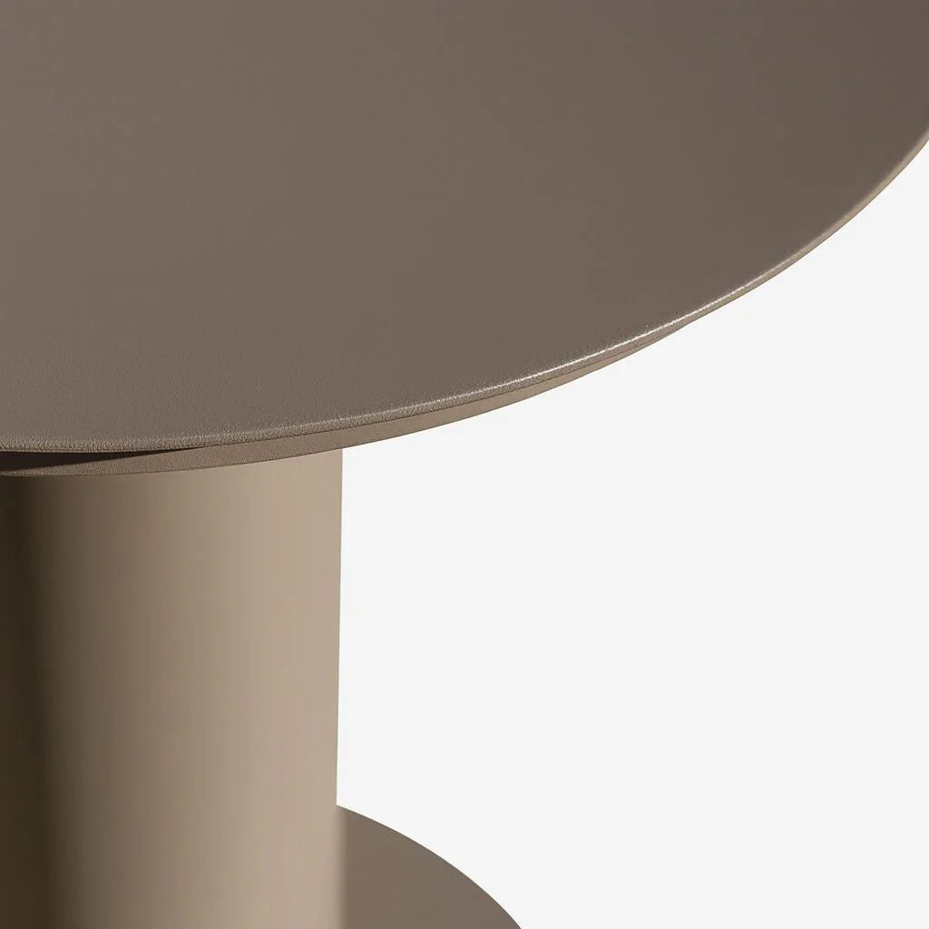 Round beige metal side table closeup showing smooth surface and sturdy cylindrical base