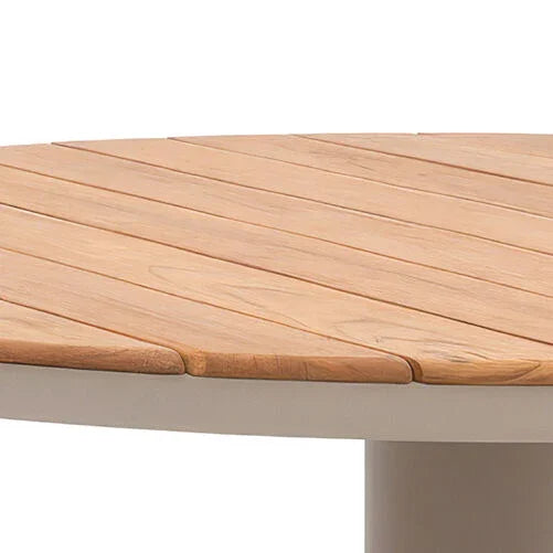 Round wood top dining table with light natural finish, angled close-up view