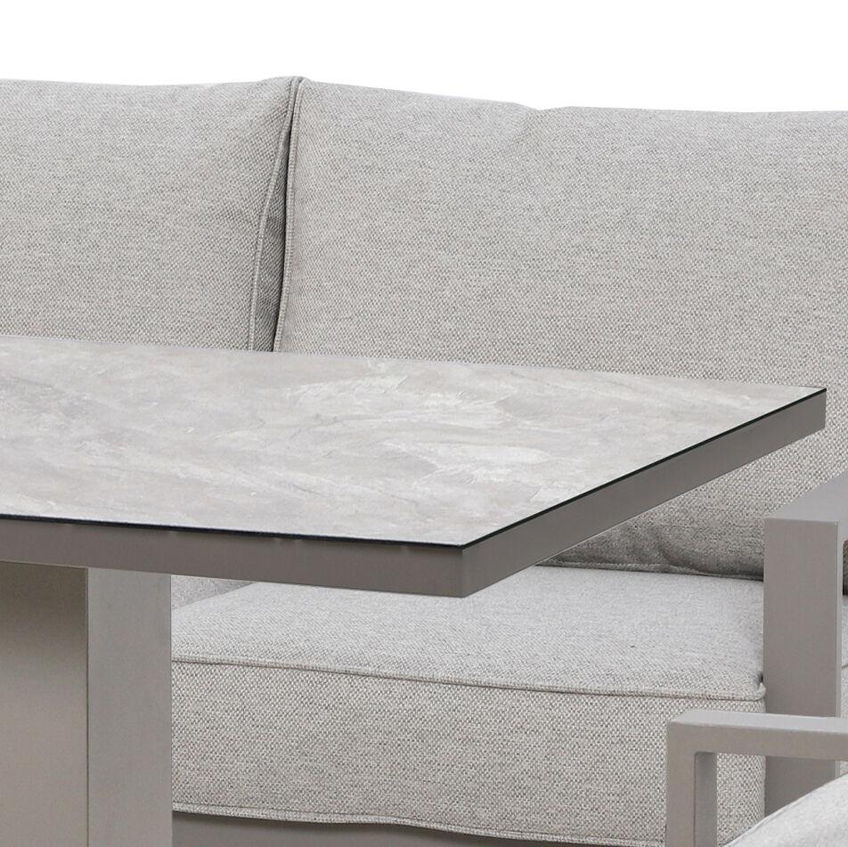 Grey fabric sofa with high back cushions and rectangular stone top table corner
