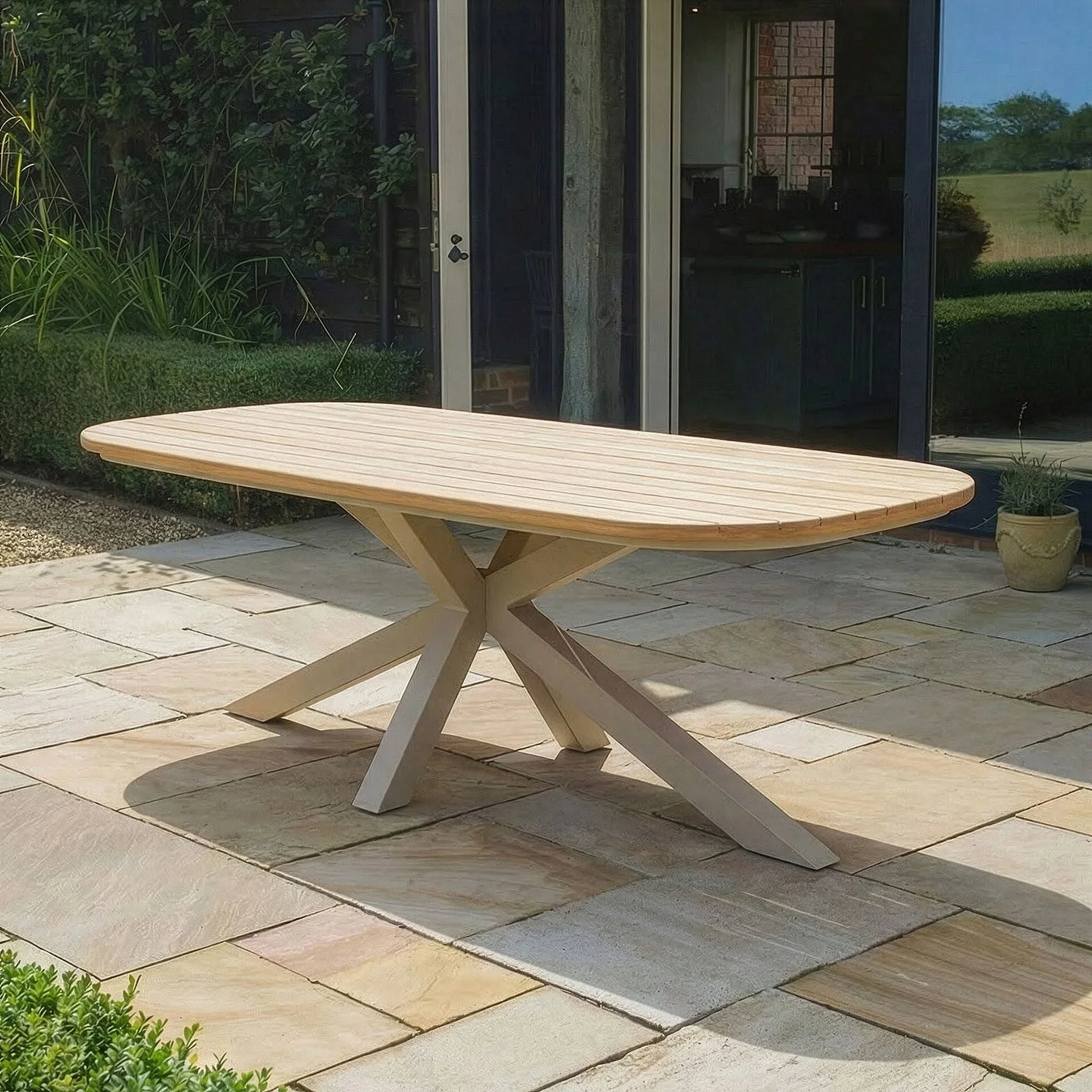 Rectangular wooden outdoor dining table with pedestal legs on stone patio