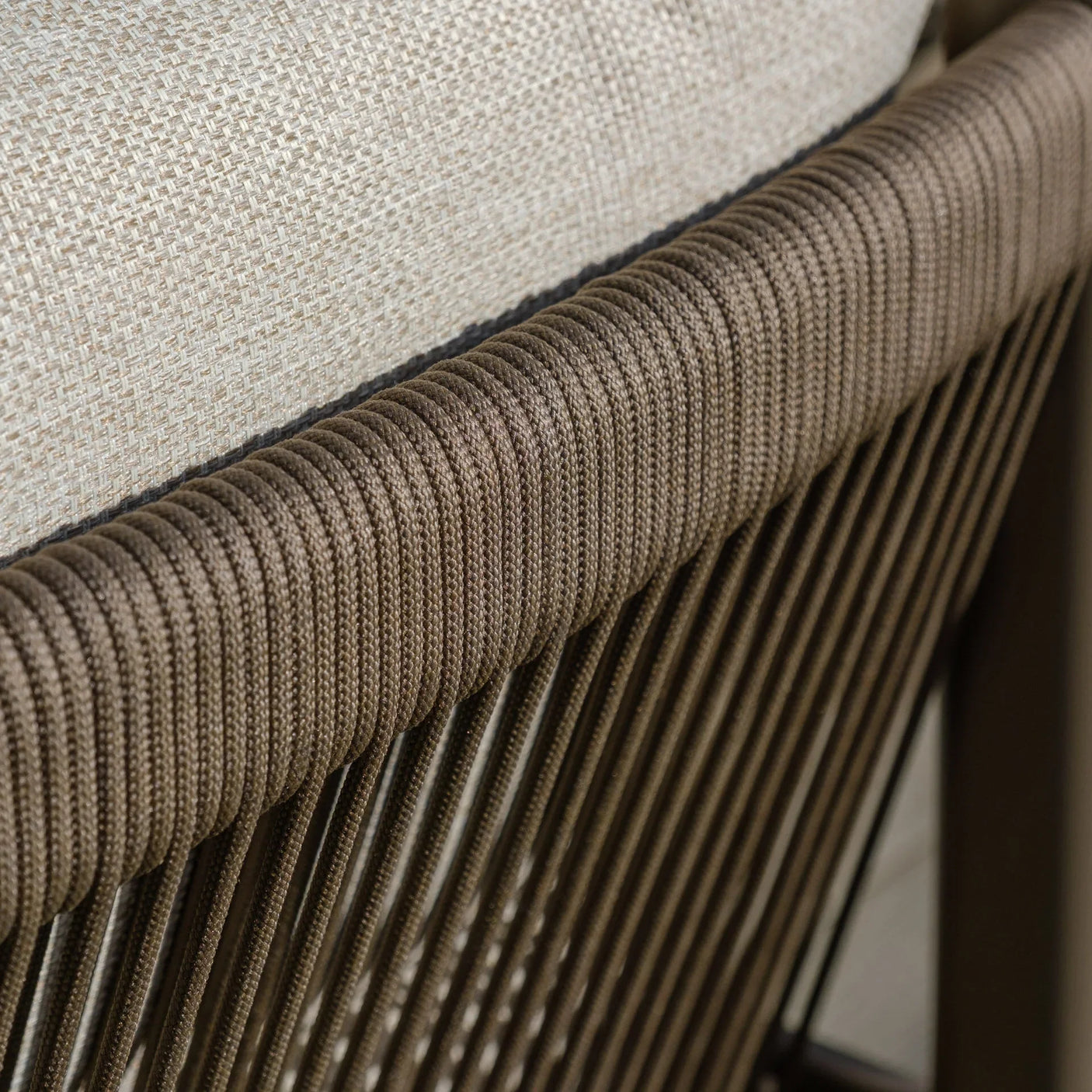 Close-up of rope-wrapped sofa armrest with beige cushion, highlighting outdoor sofa detail