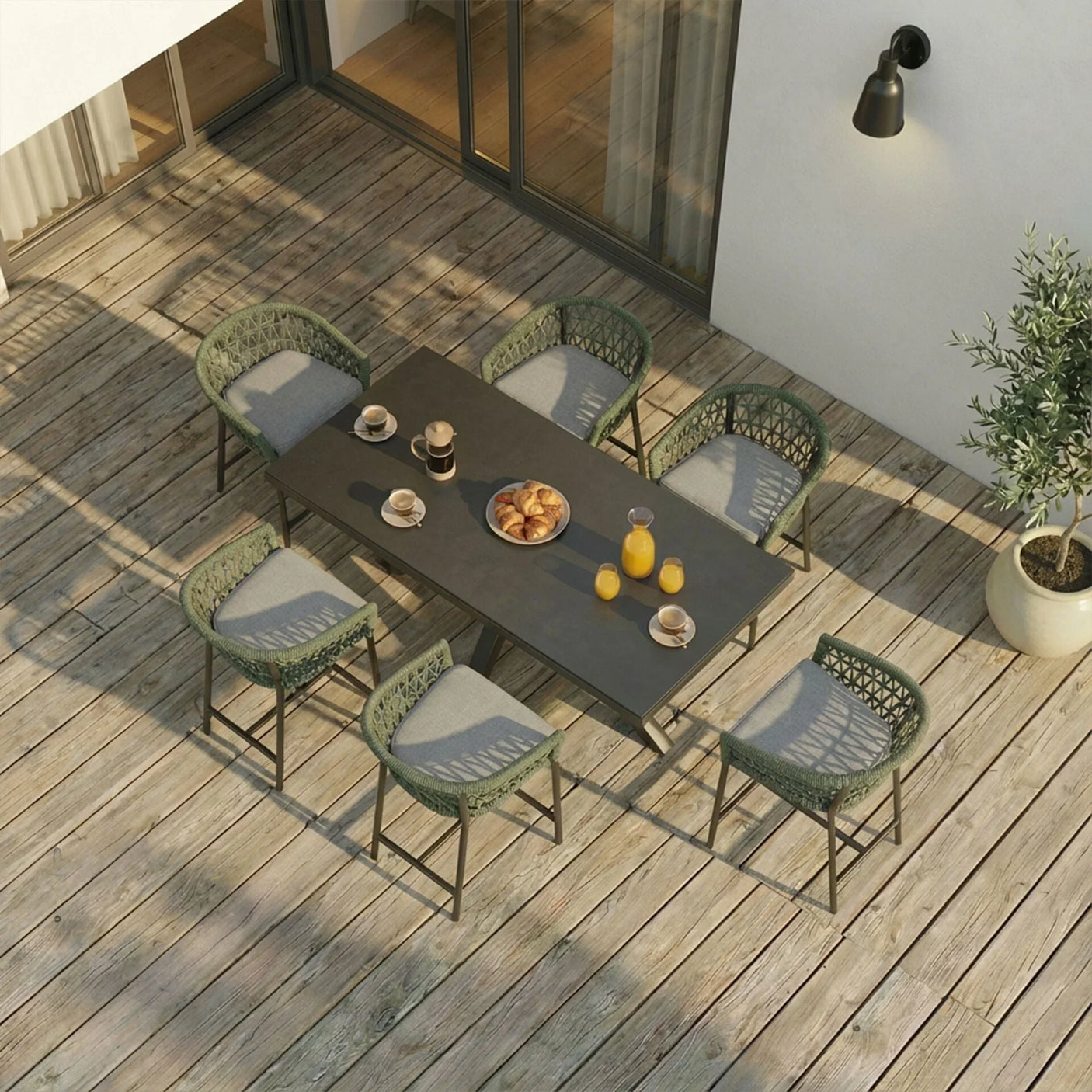 Outdoor garden dining set with six green woven chairs and rectangular table on wooden decking