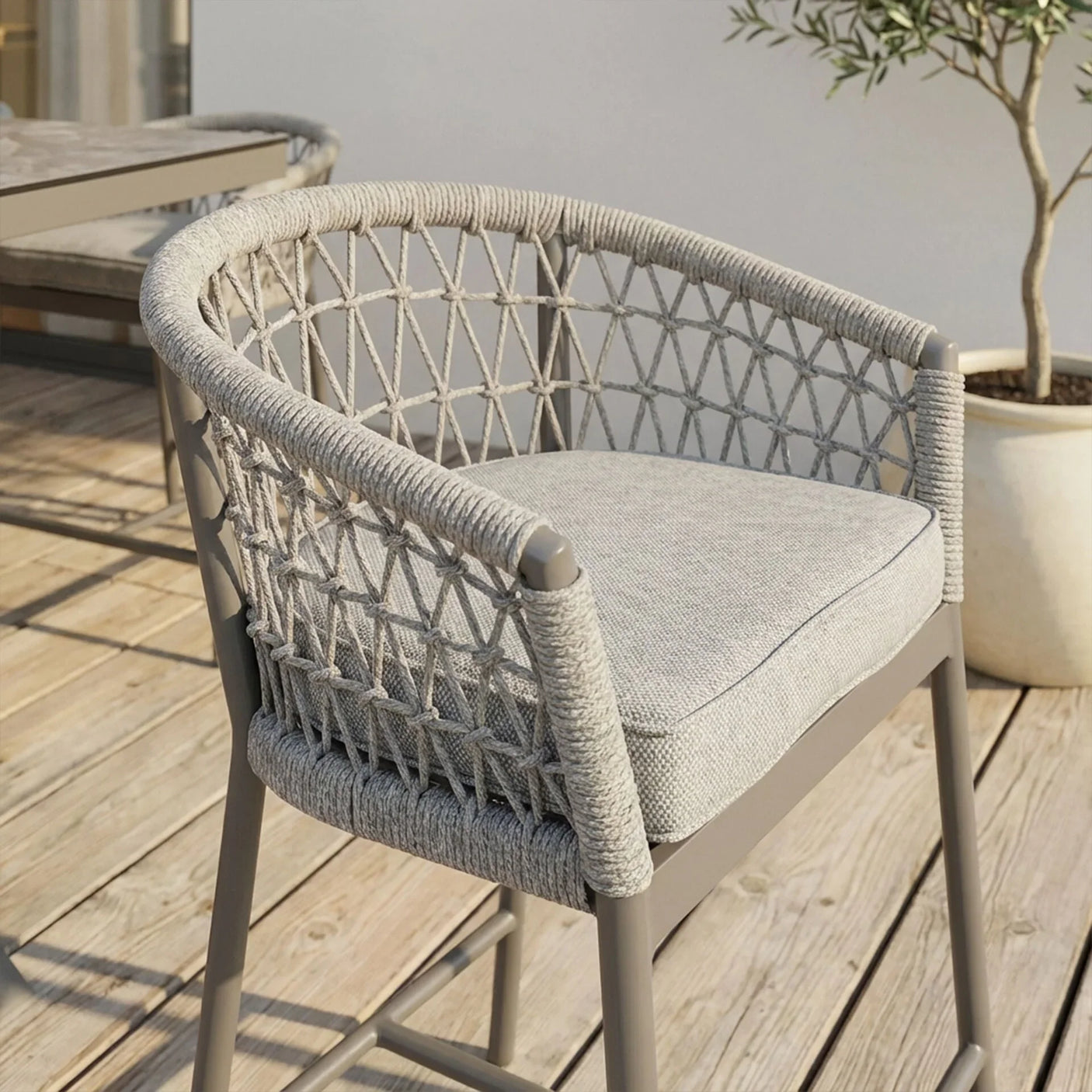 Outdoor rope weave dining chair with grey cushion on wooden decking
