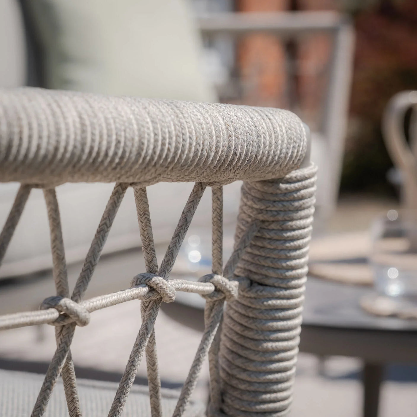 Close-up of grey rope outdoor furniture armrest with woven detailing