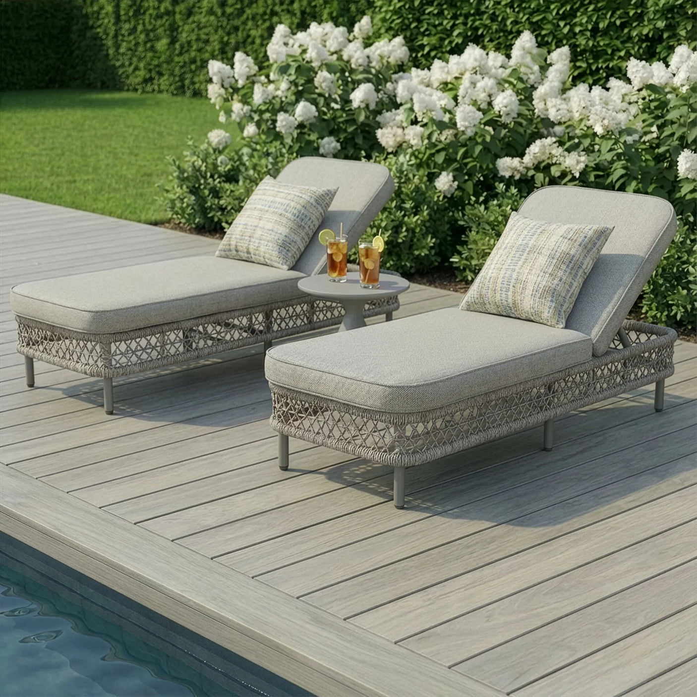 Outdoor sun lounger set with cushions and side table by pool on wooden deck