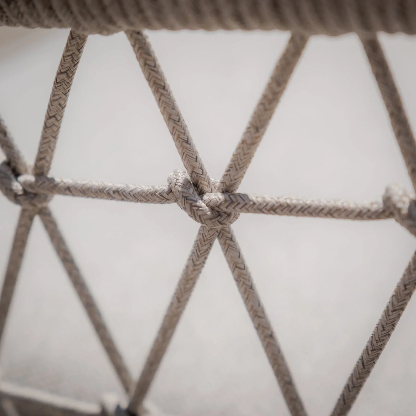 Close view of beige woven rope detail on outdoor furniture frame