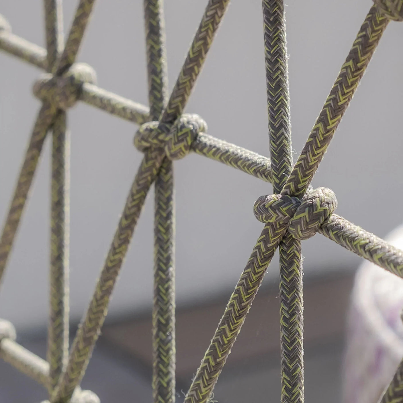 Closeup of outdoor sofa rope weave pattern with textured knots and neutral colors