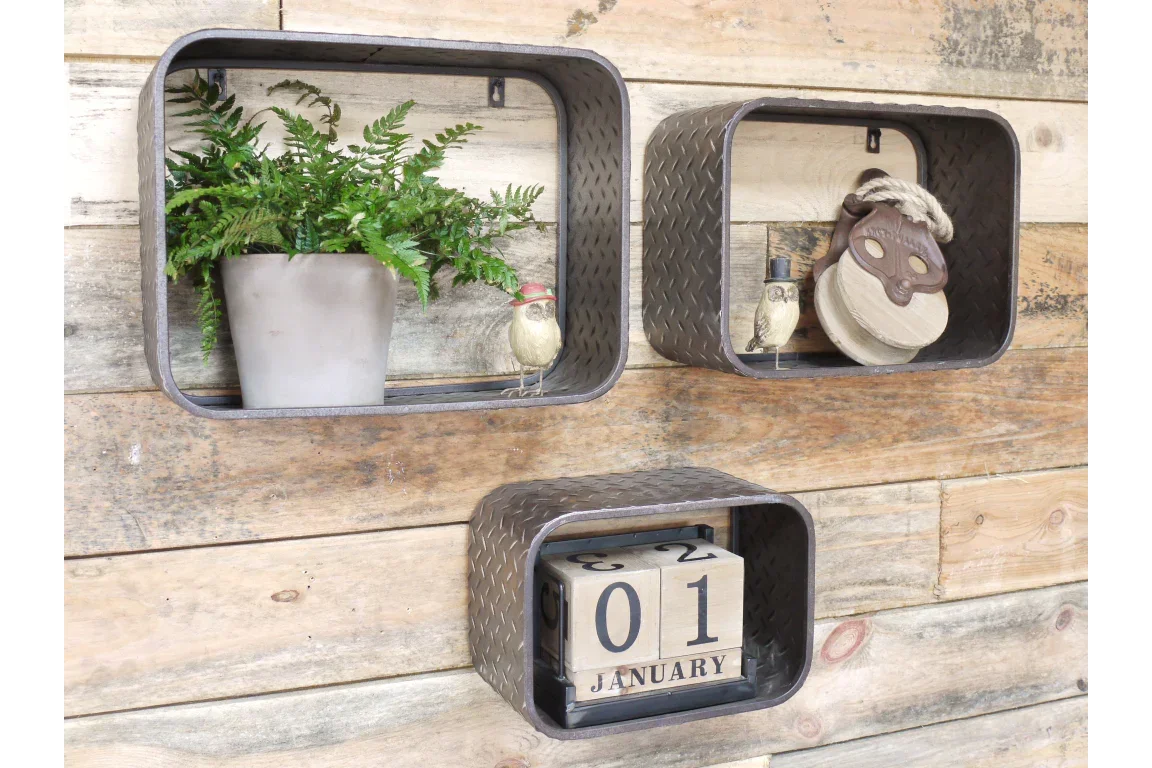 Set of three metal wall shelves with decorative items and wooden block calendar on wood wall