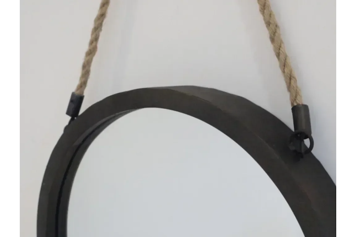 Round wall mirror with black metal frame and rope hanging detail against white background