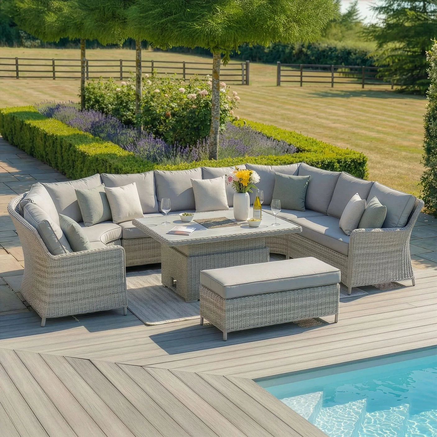 Grey rattan garden corner sofa set with cushions, glass-top table and bench by pool