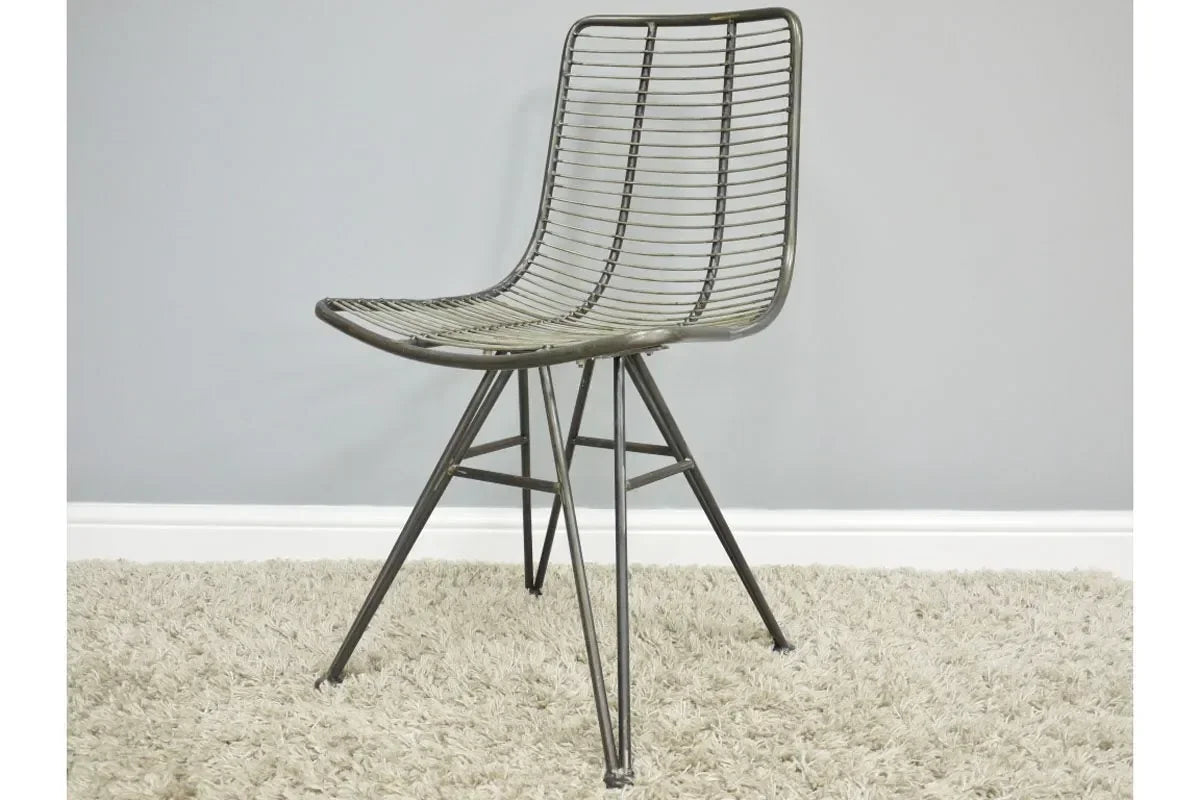 Metal wire accent chair with angled legs on beige carpet against grey wall