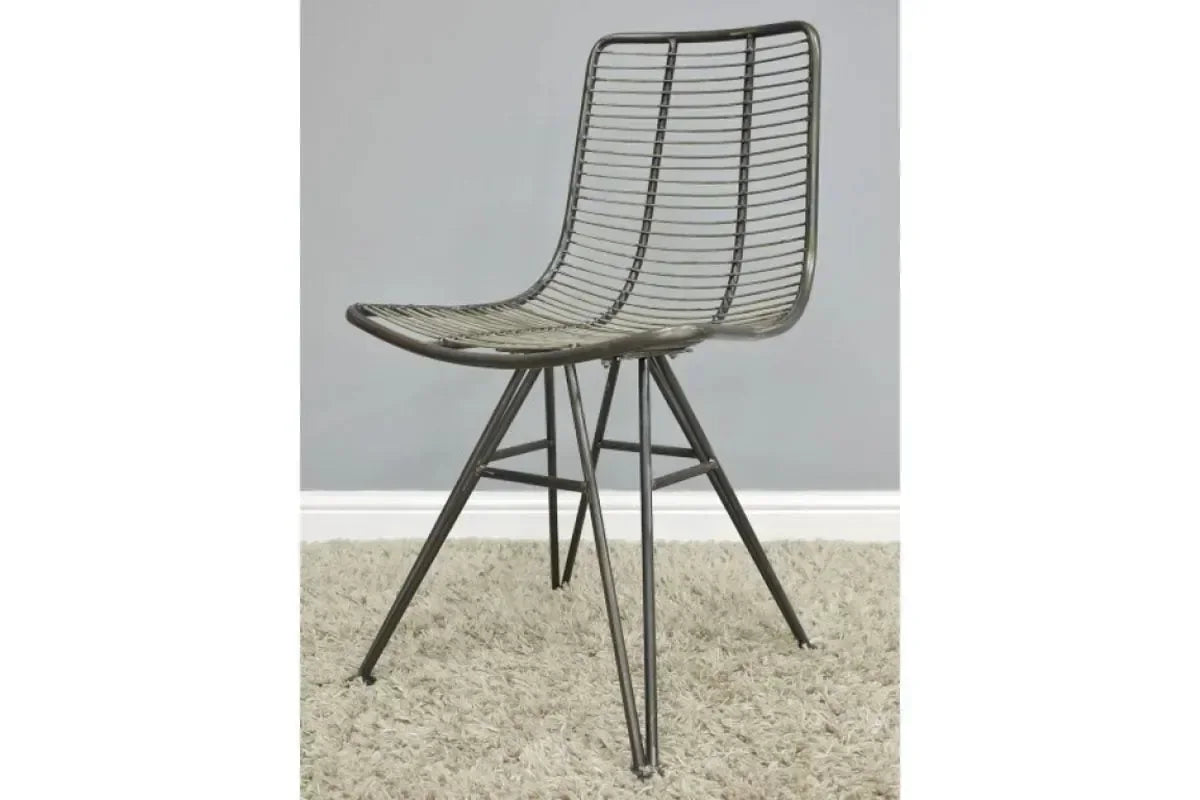 Black rattan dining chair with metal legs on beige carpet against grey wall